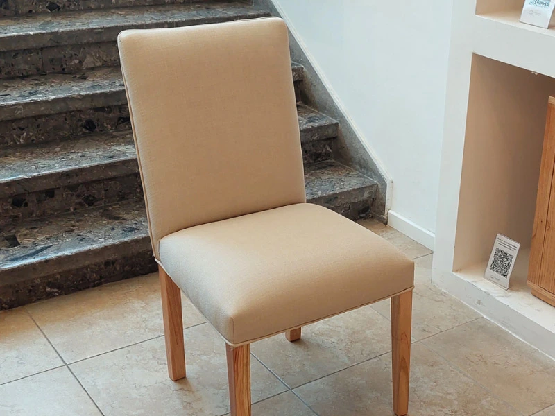 Silla de comedor de respaldo alto tapizada en tela beige con patas de madera