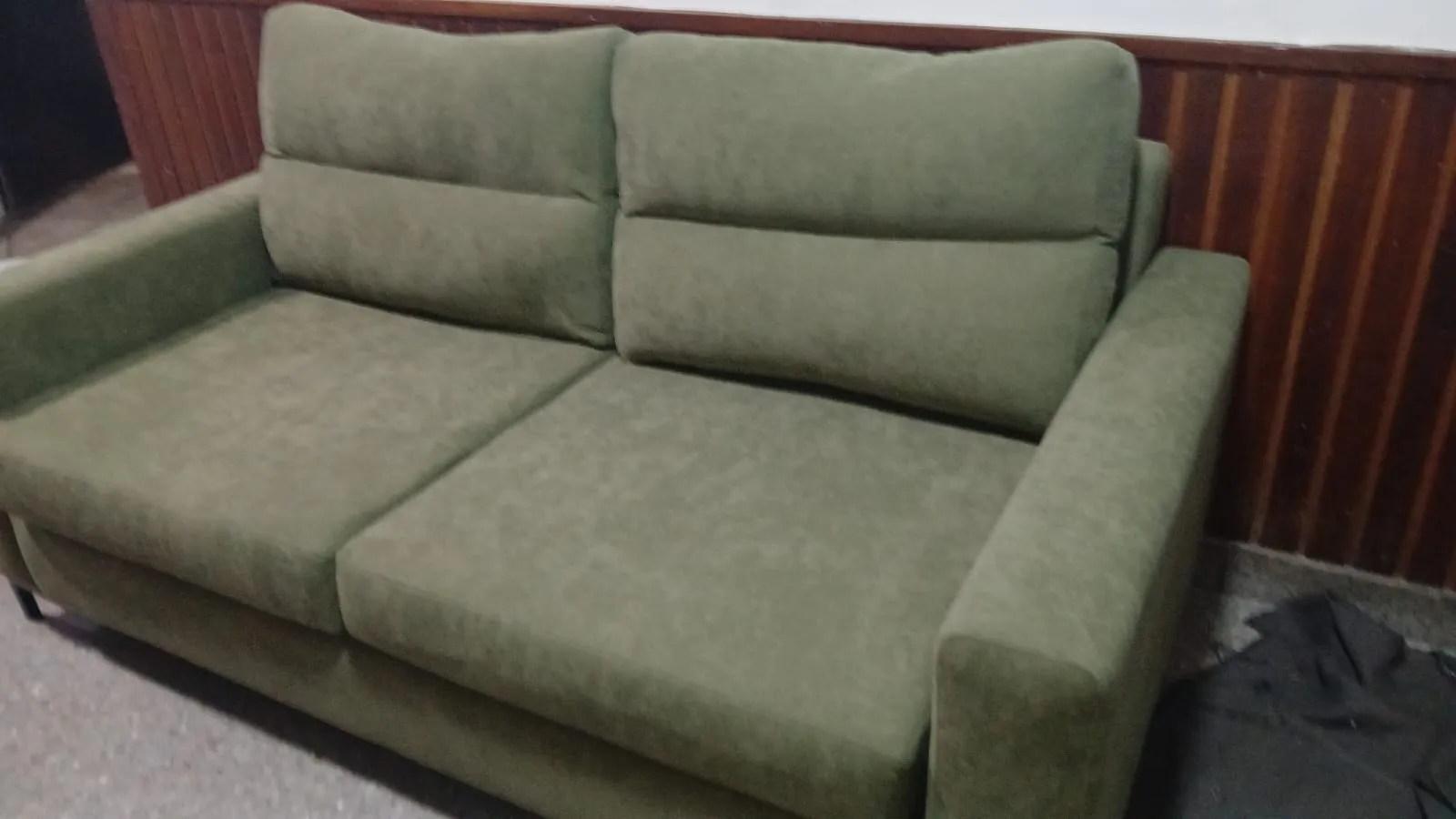 Sillón individual tapizado en tela azul con brazos de madera