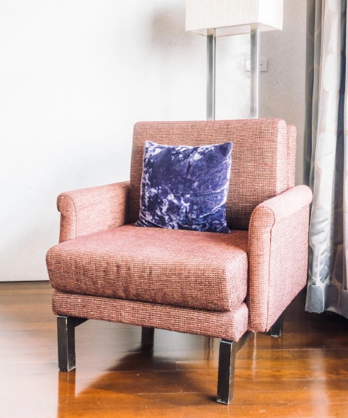 Sillón individual tapizado en tela texturada rosa viejo, con patas metálicas